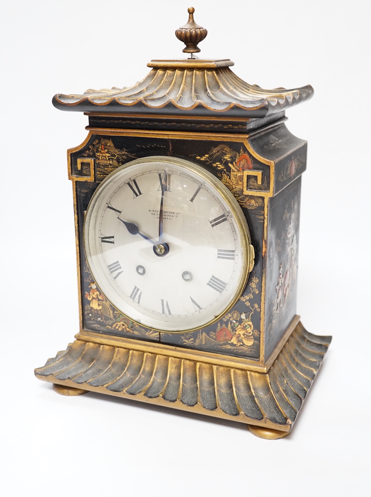 A George V chinoiserie lacquered mantel clock, decorated in relief with figures and pagodas, dial inscribed Birch & Gaydon, 31cm high